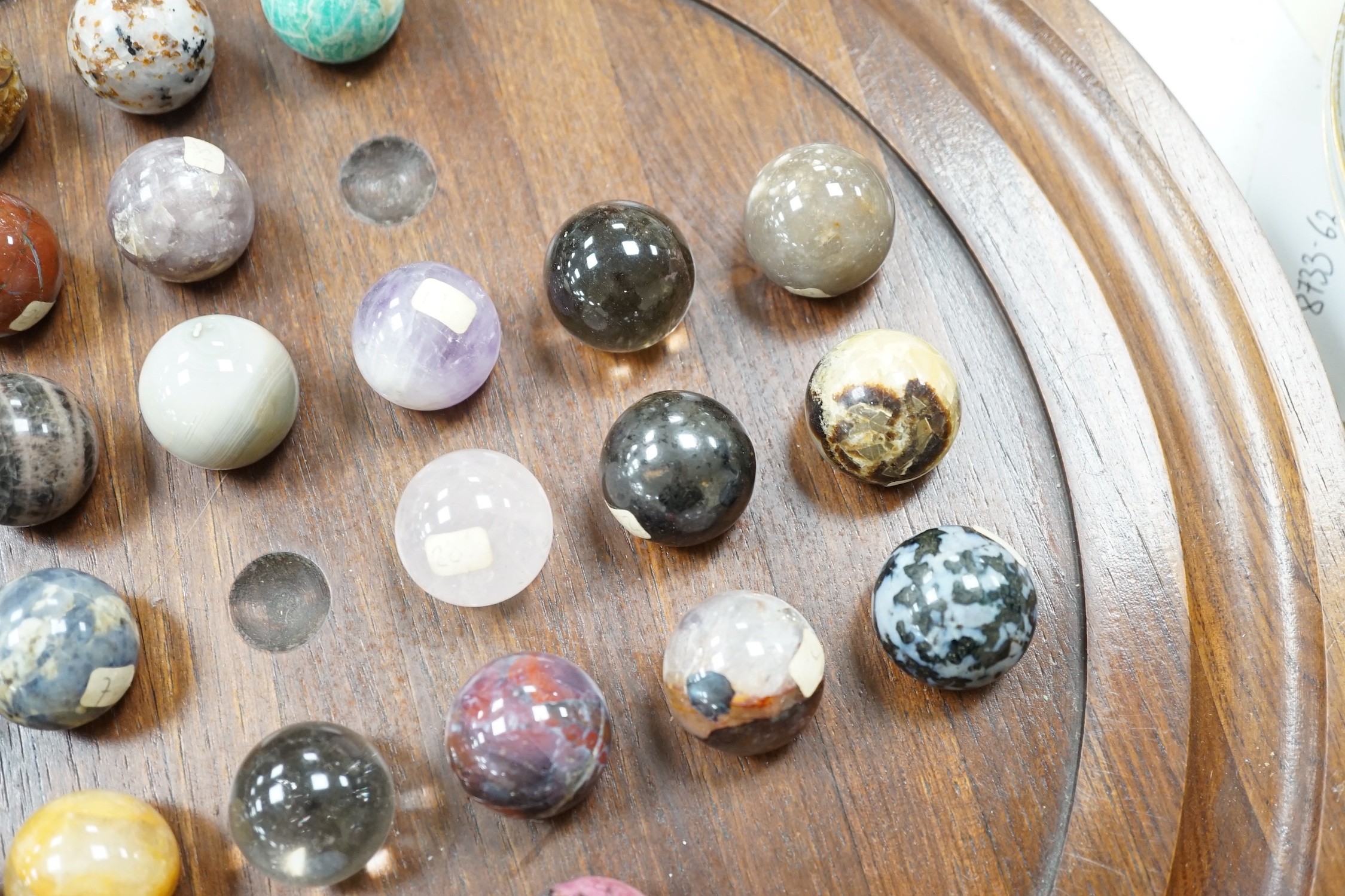 A large mahogany solitaire board with large specimen hardstone marbles, 42cm